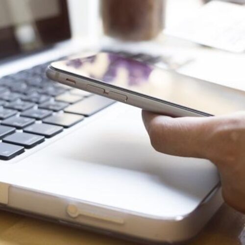 Woman using laptop and mobile phone to online shopping and pay by credit card. Mobile focus. Vintage tone, Retro filter effect, Soft focus, Low light.(selective focus)